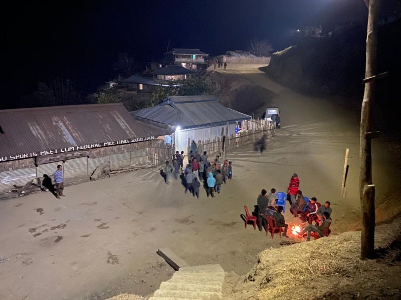 Residents of Shinnyu village gather outside at night after the electrification of the village.